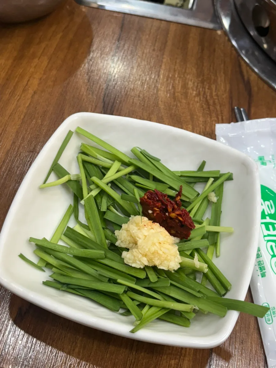 ニラに添えたにんにくと赤い薬味
