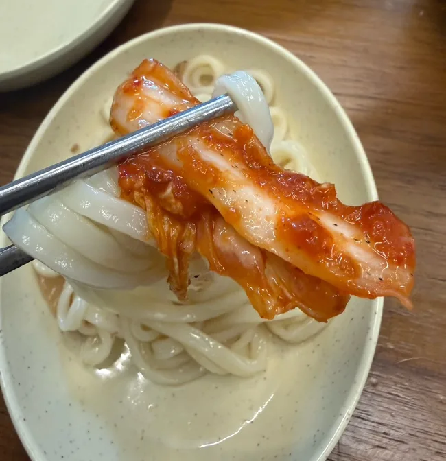麺に赤いキムチをのせる