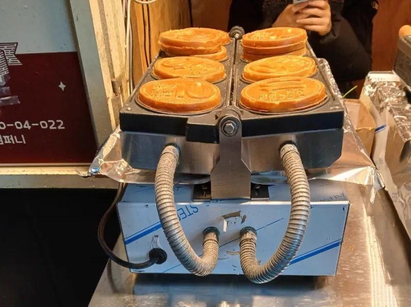 焼き型に並ぶ硬貨形の焼き菓子