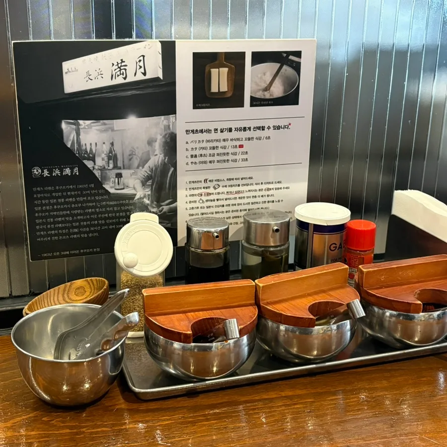 長浜満月 本店 — 麺の硬さの案内と卓上の薬味