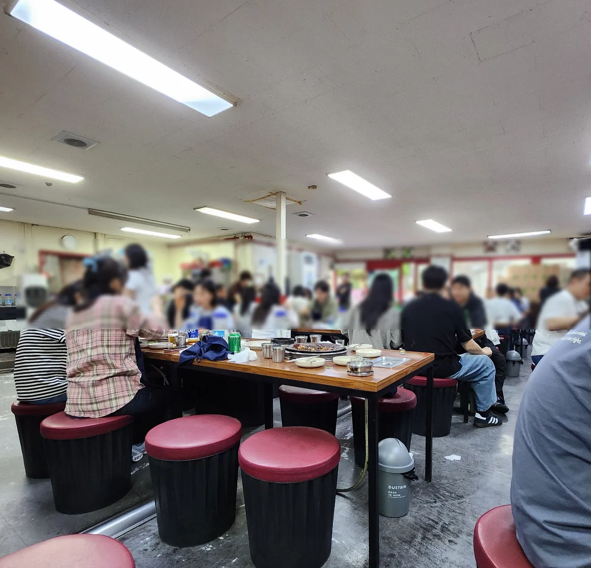 客が集う店内と赤い丸椅子
