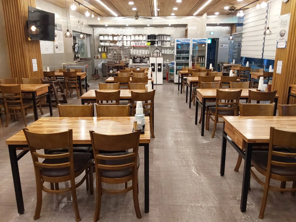 南浦ソルロンタン — 木のテーブルが並ぶ店内