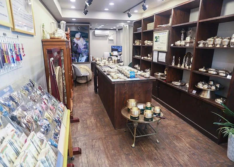 木の棚に金属食器が並ぶ売り場