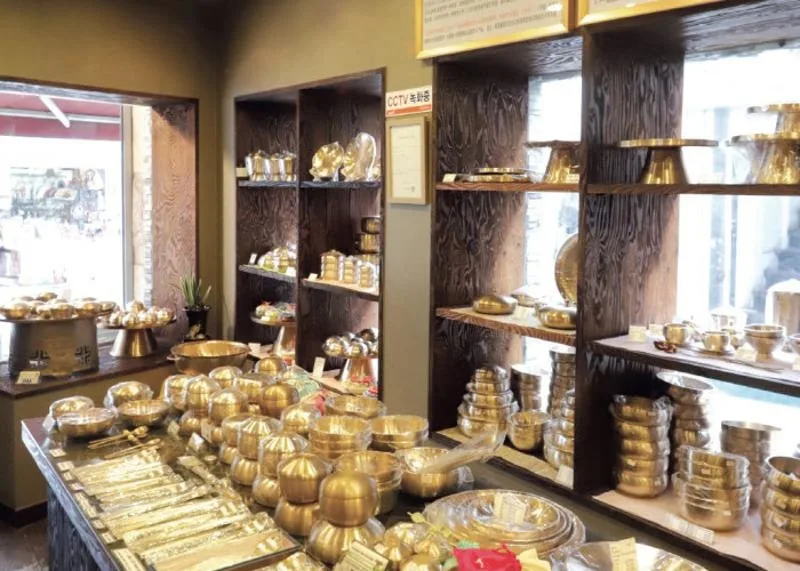 金色の器が棚いっぱいに並ぶ店内