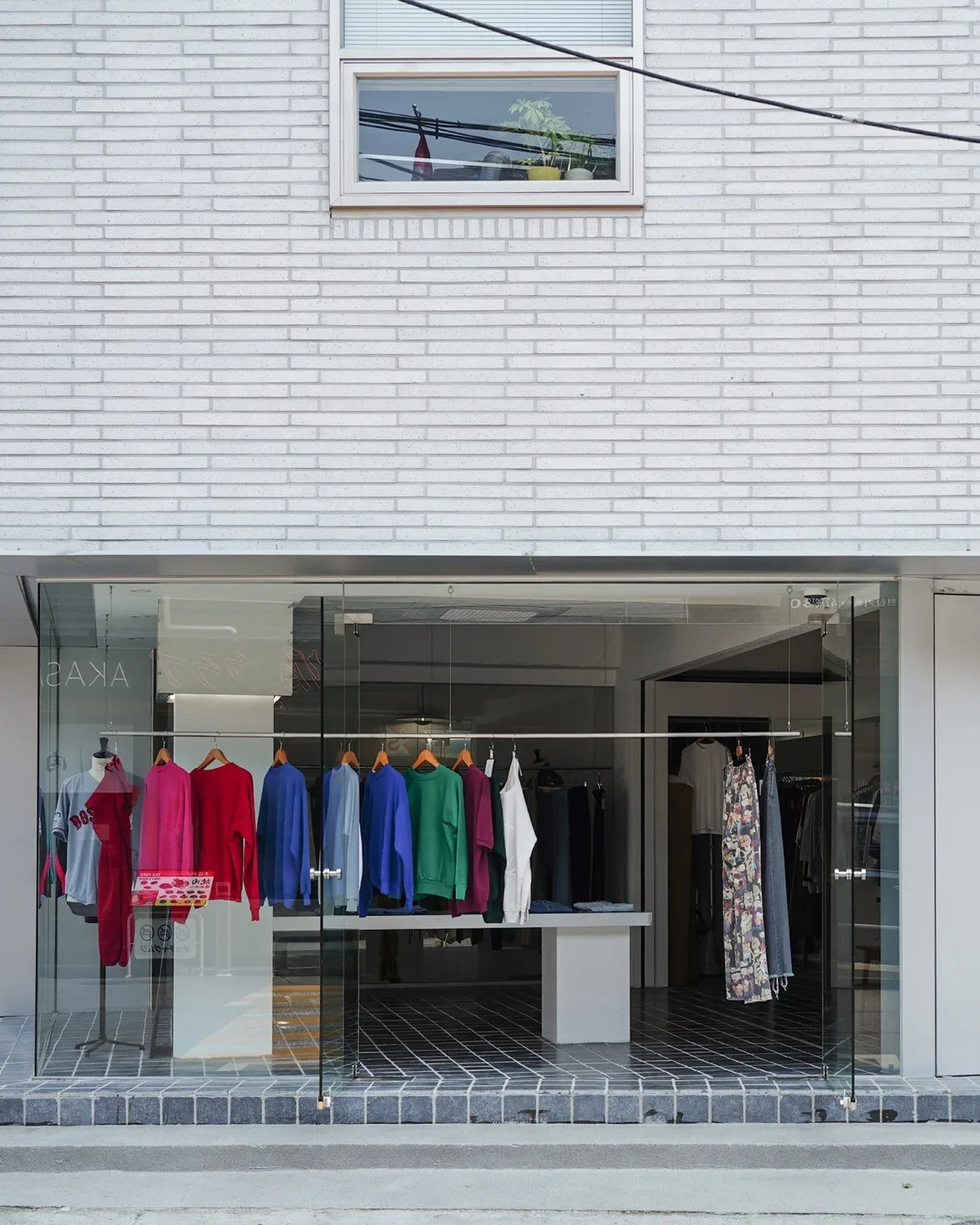 NEAT SEOUL — 色鮮やかな服が見えるガラス張りの店