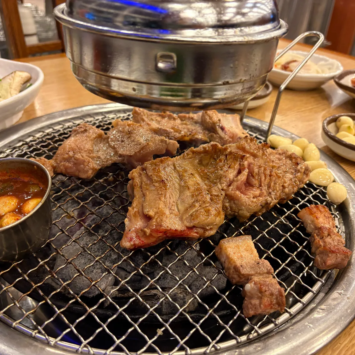 網で焼く豚肉と丸ごとのニンニク