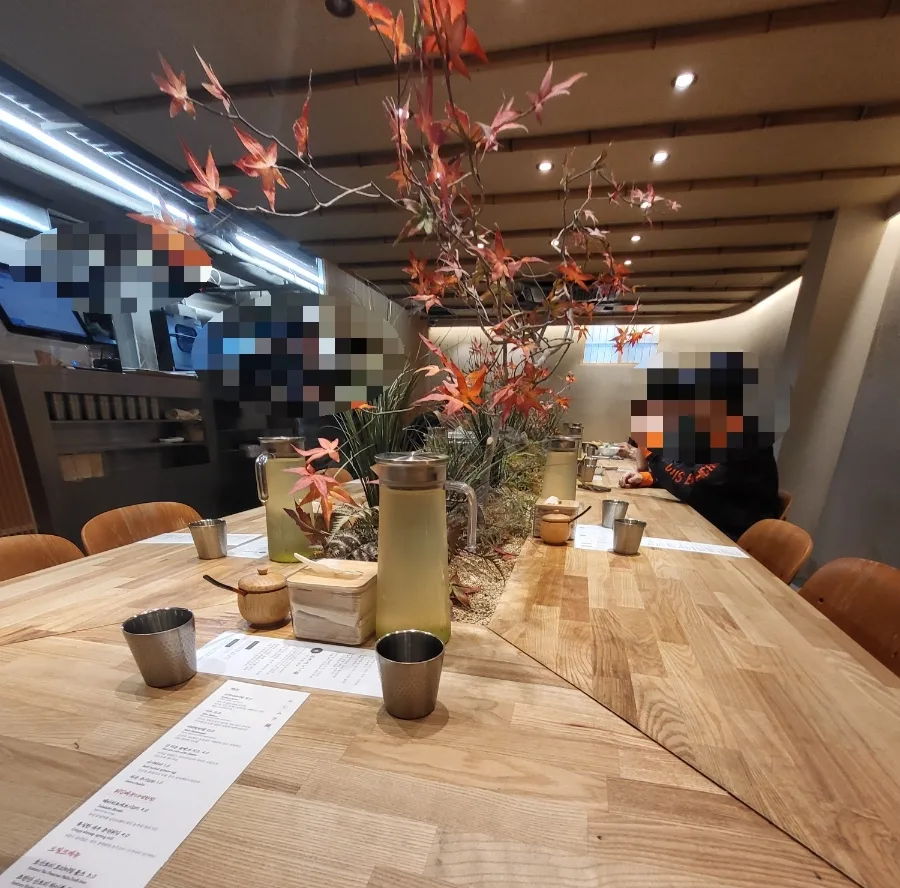 ニシムラ麺 延南本店 — 草木を囲む長い共用テーブル