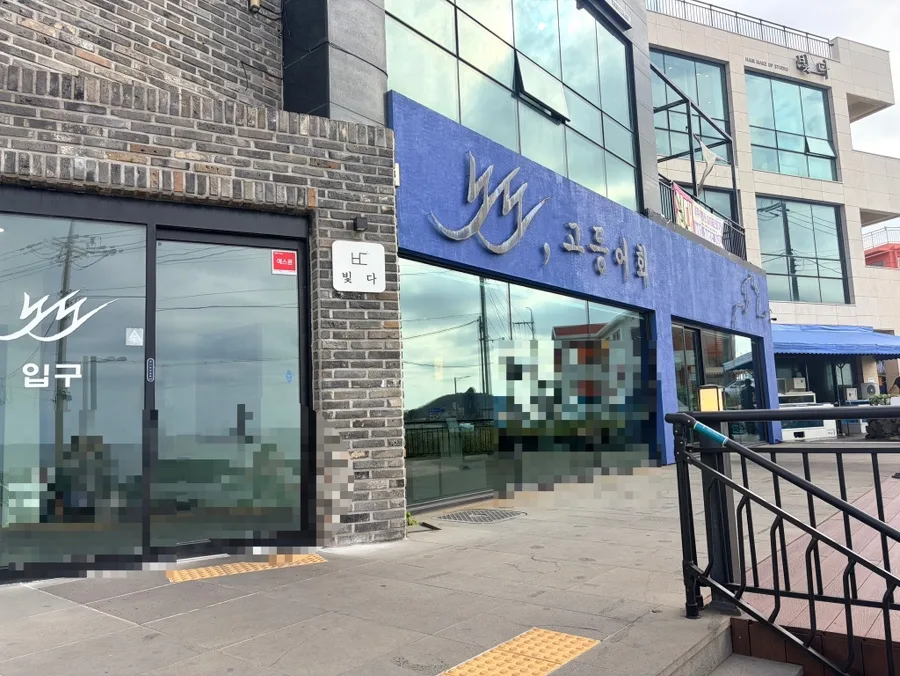 ノド・コドゥンオフェ — 青い看板とガラス張りの店構え