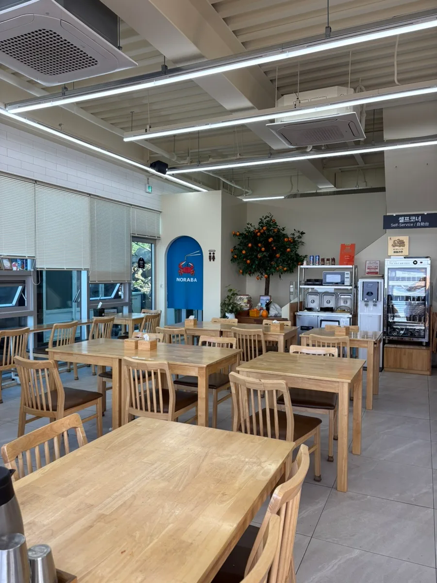 ノラバ — 木のテーブルが並ぶ店内