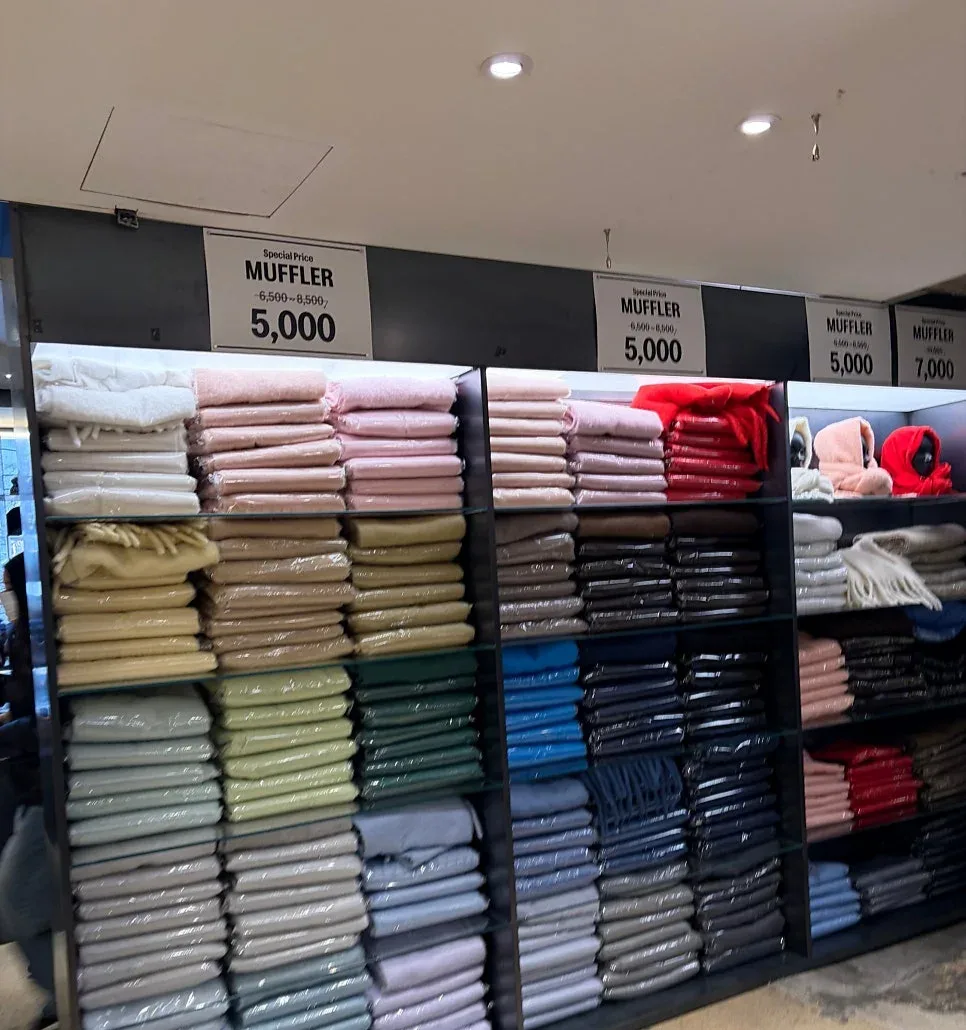 NYUNYU 東大門店 — 色別に積まれたマフラーの棚