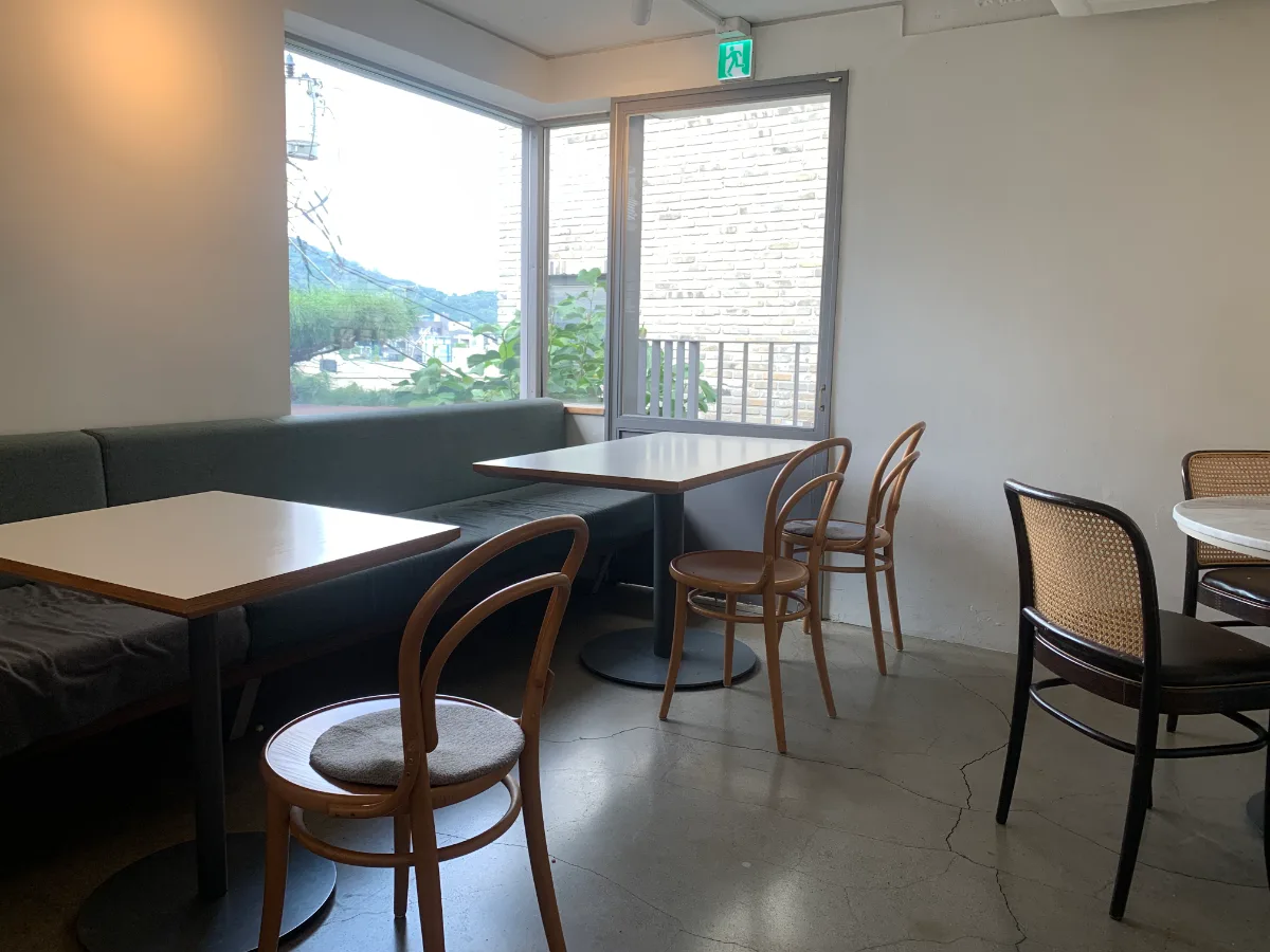 OASIS 漢南店 — 窓際のソファ席と木製の椅子