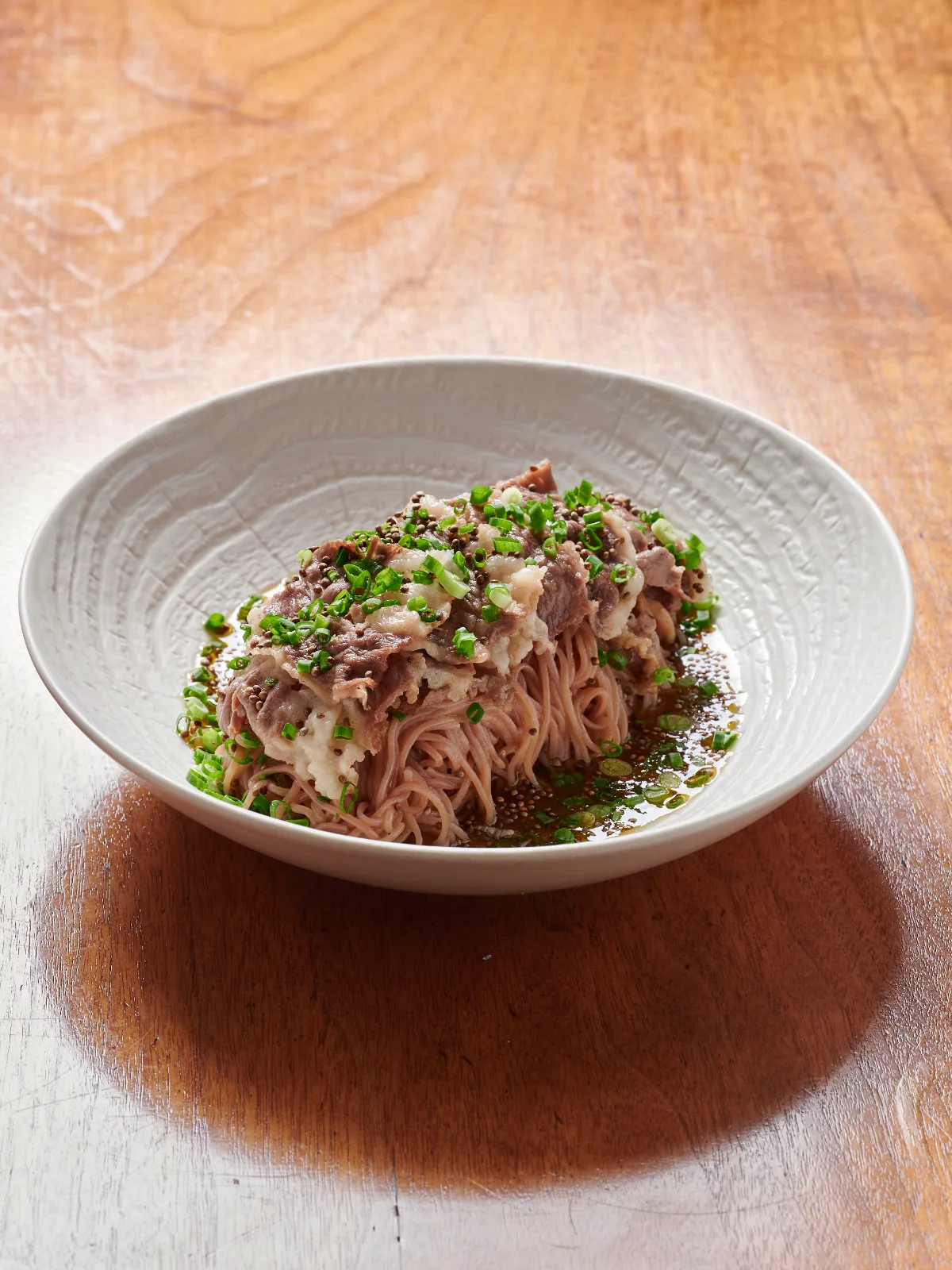 牛バラ肉とネギ、エゴマの粒をのせた麺