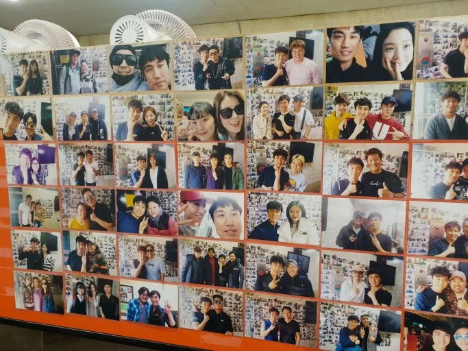 芸能人の写真が並ぶ店内の壁