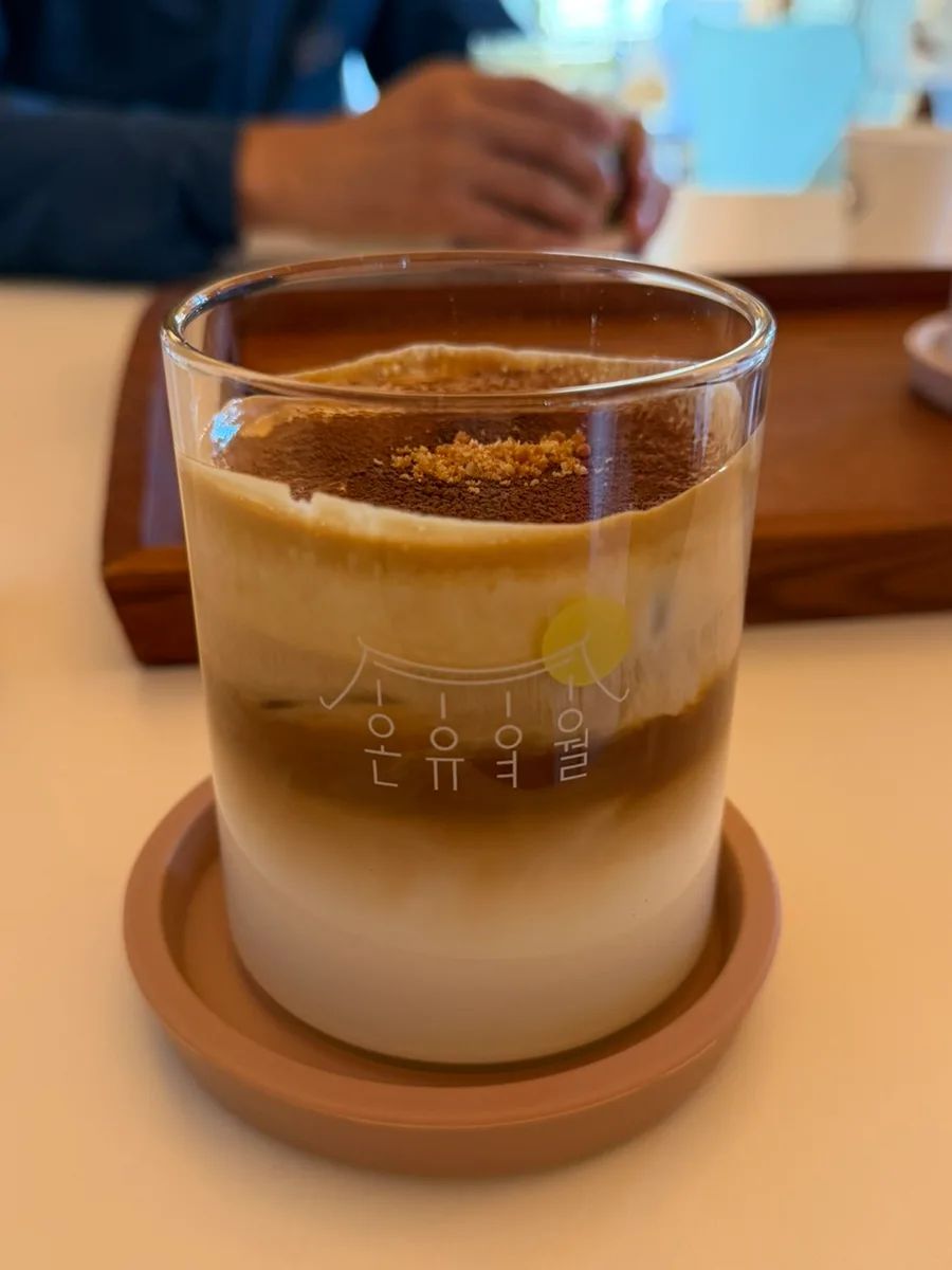 オンユヨウォル 本店 — 茶色の粉をのせた層状のラテ