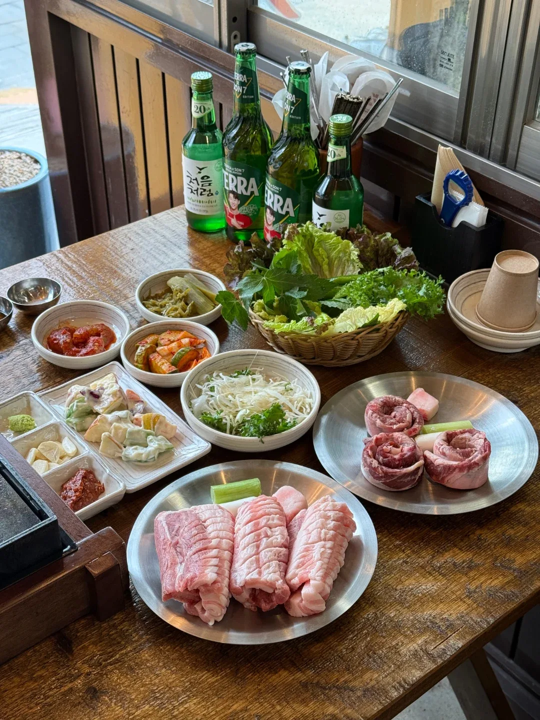 オシンデジカルビ 東大門店 — 豚肉と葉野菜が並ぶ食卓