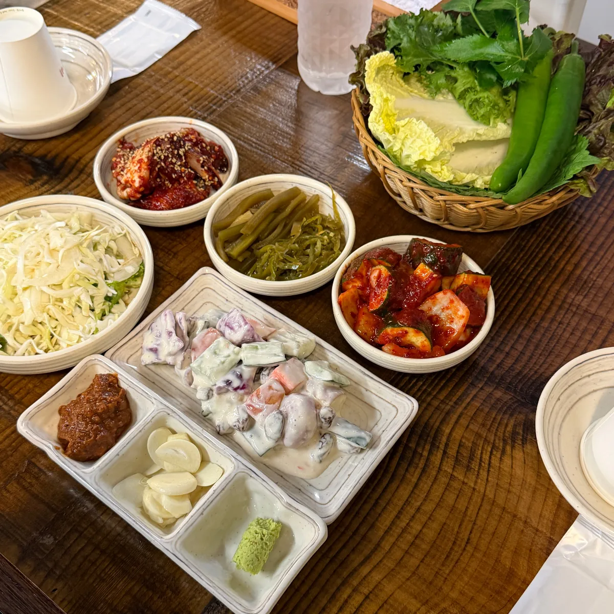 オシンデジカルビ 東大門店 — ヤンニョムケジャンや包み野菜が並ぶ付け合わせ