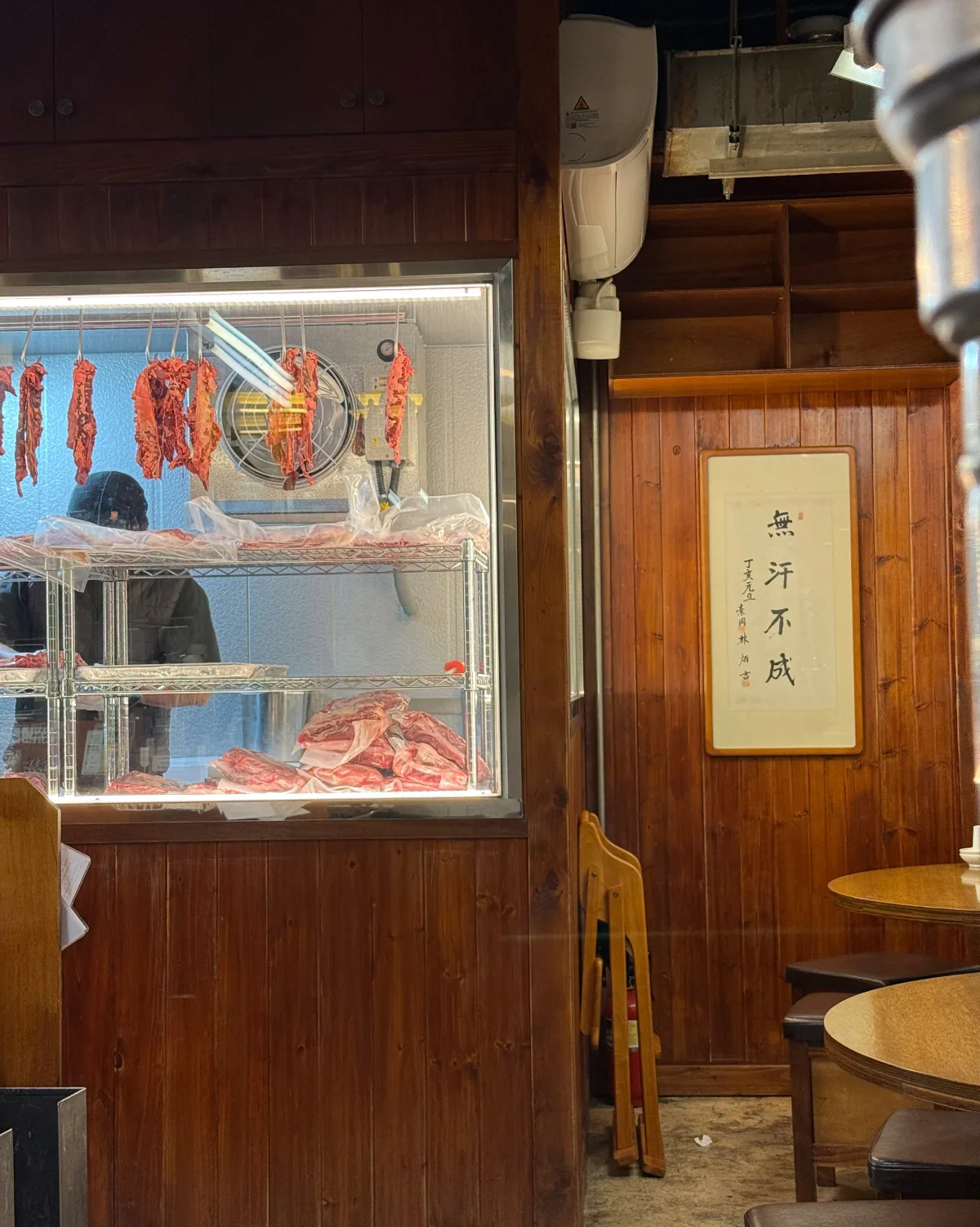 肉を吊るしたガラス張りの冷蔵室と木の壁