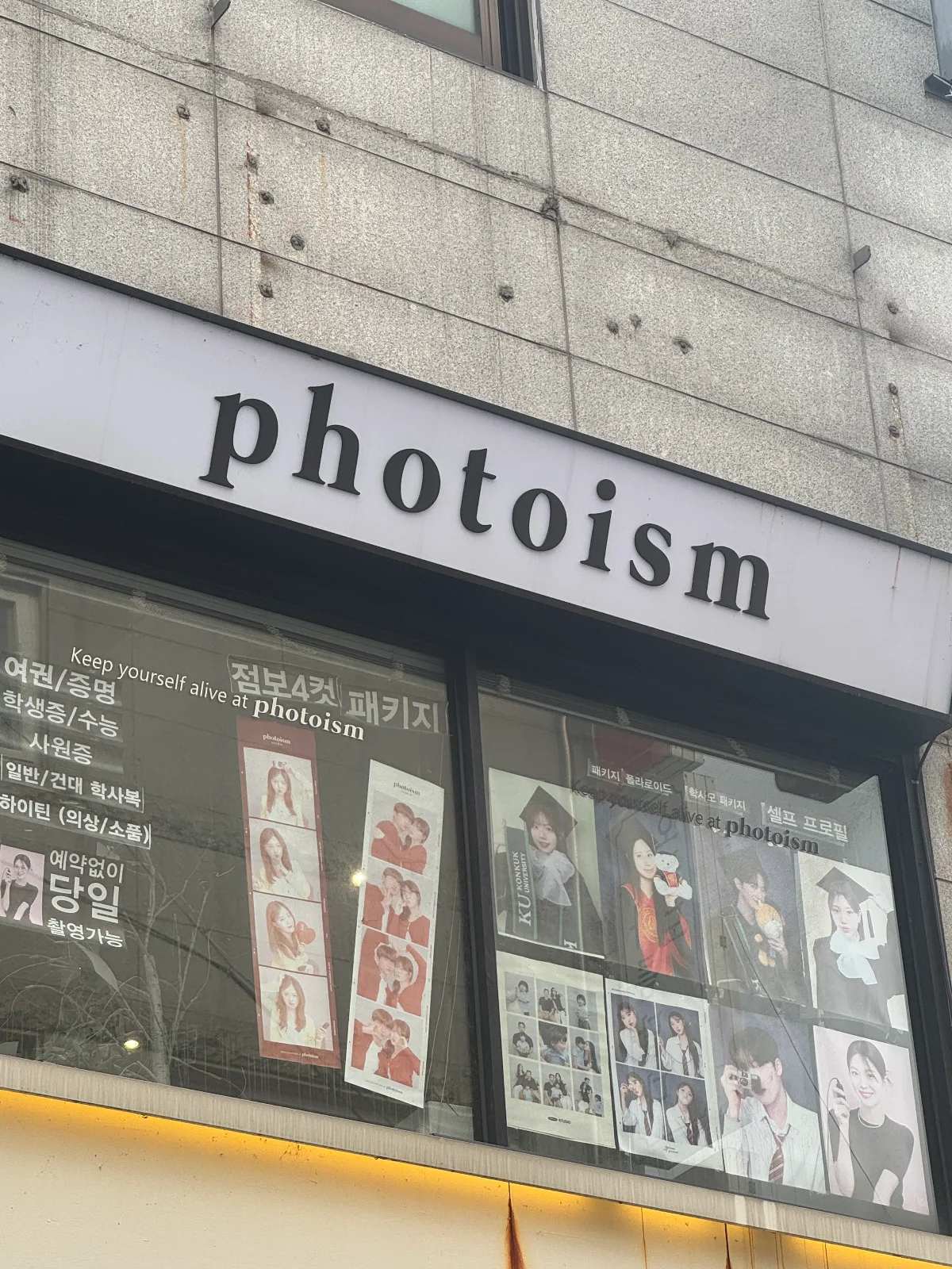 photoism studio 建大店 — フォトイズムの看板と窓の写真