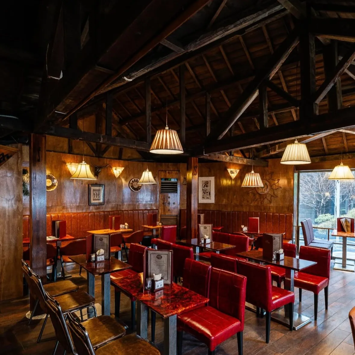 PIRULTZ COFFEEHOUSE 市庁店 — 木の梁と赤い椅子が並ぶ客席