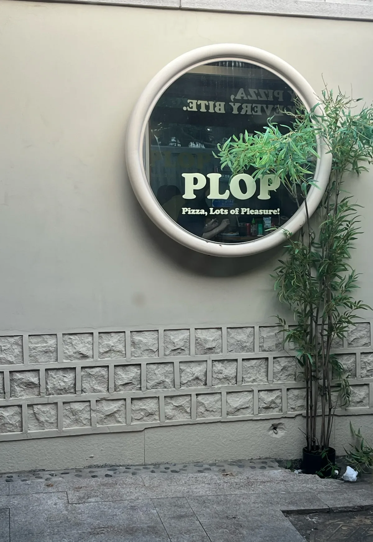 丸窓にPLOPのロゴが入った外壁
