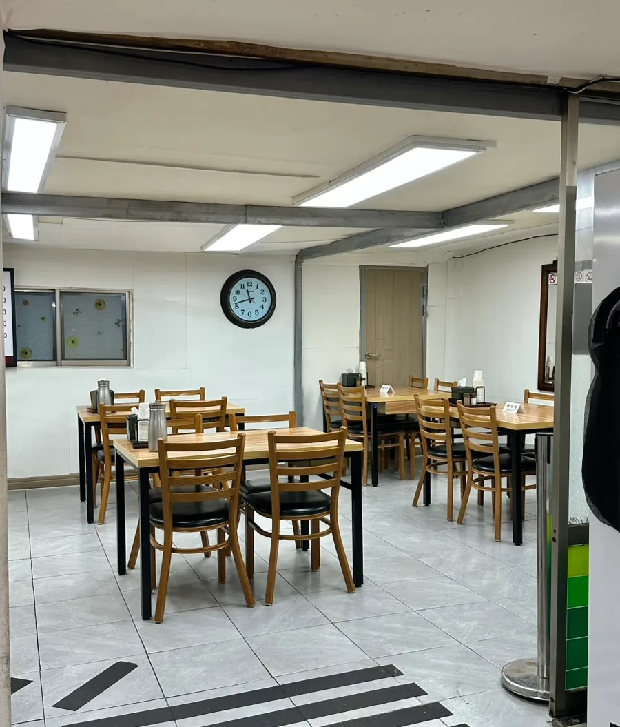 ポハンテジクッパ — 木のテーブルと椅子が並ぶ店内