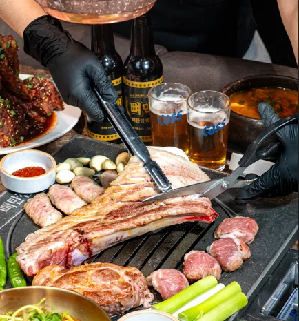 スタッフが骨付き肉をはさみで切り分ける様子