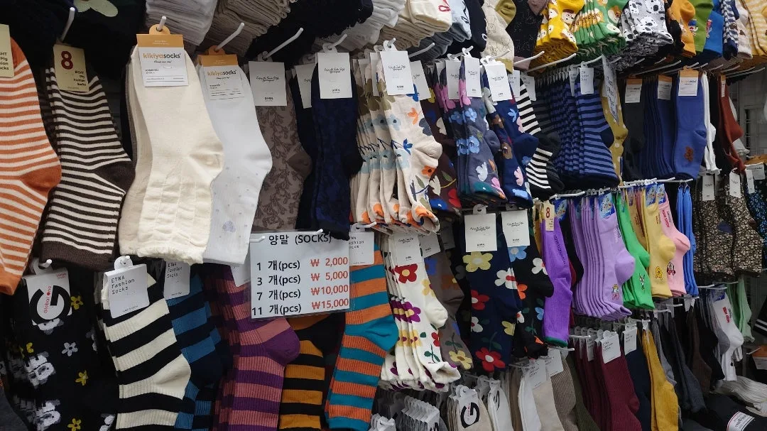 1足から11足まで、枚数ごとの値段を掲げた靴下の店