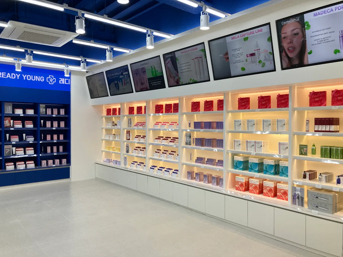 レディヤング薬局 釜山店 — 照明付きの棚に並ぶスキンケア商品