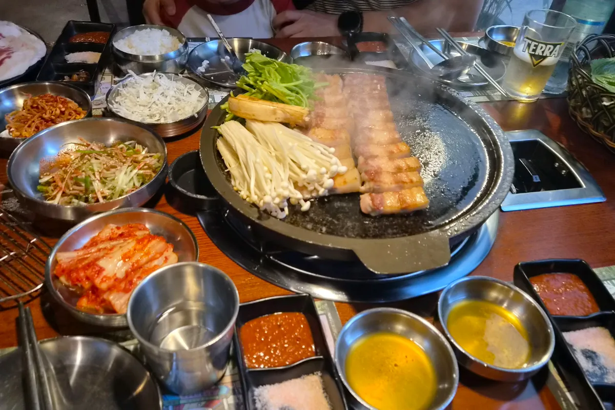 竹統領サムギョプサル 東大門店 — 豚バラと副菜が並ぶ食卓