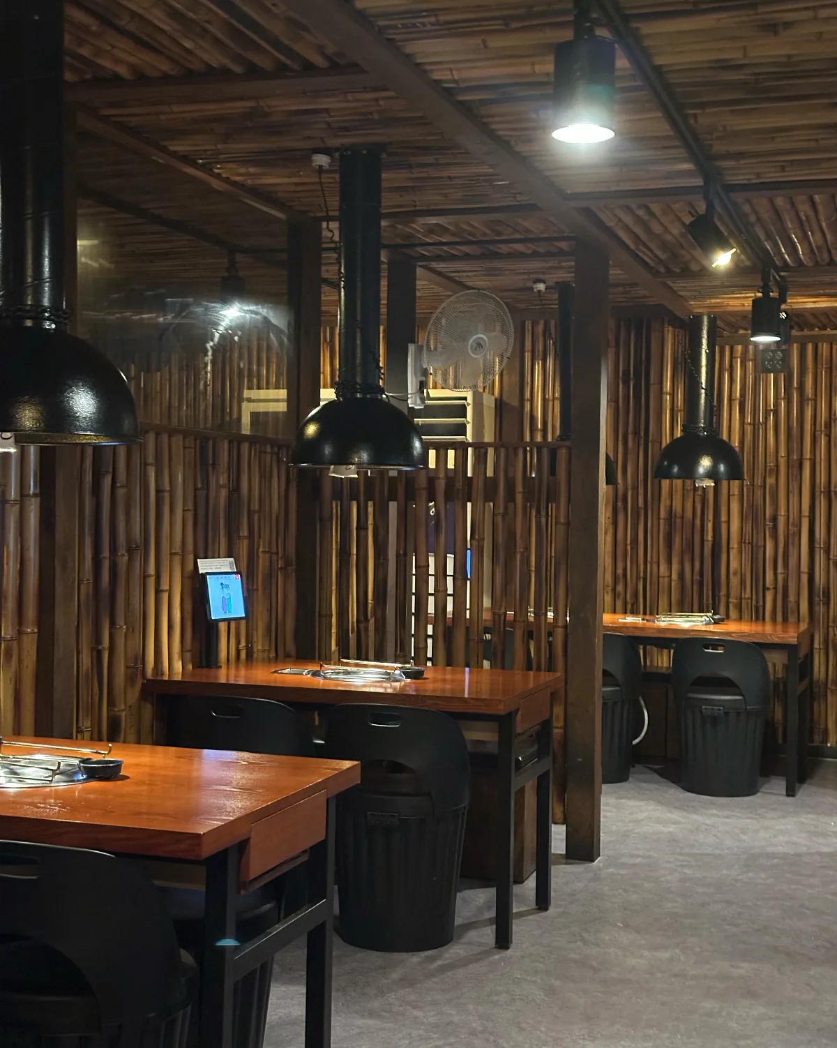 竹統領サムギョプサル 東大門店 — 竹を配した壁と焼肉用の席