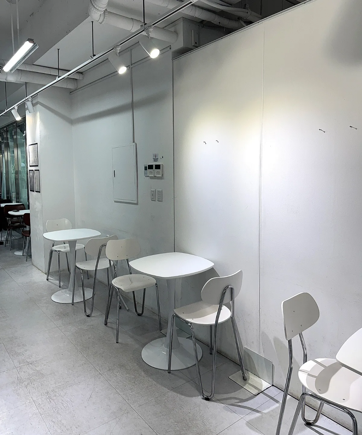 白い壁沿いに並ぶ小さなテーブル