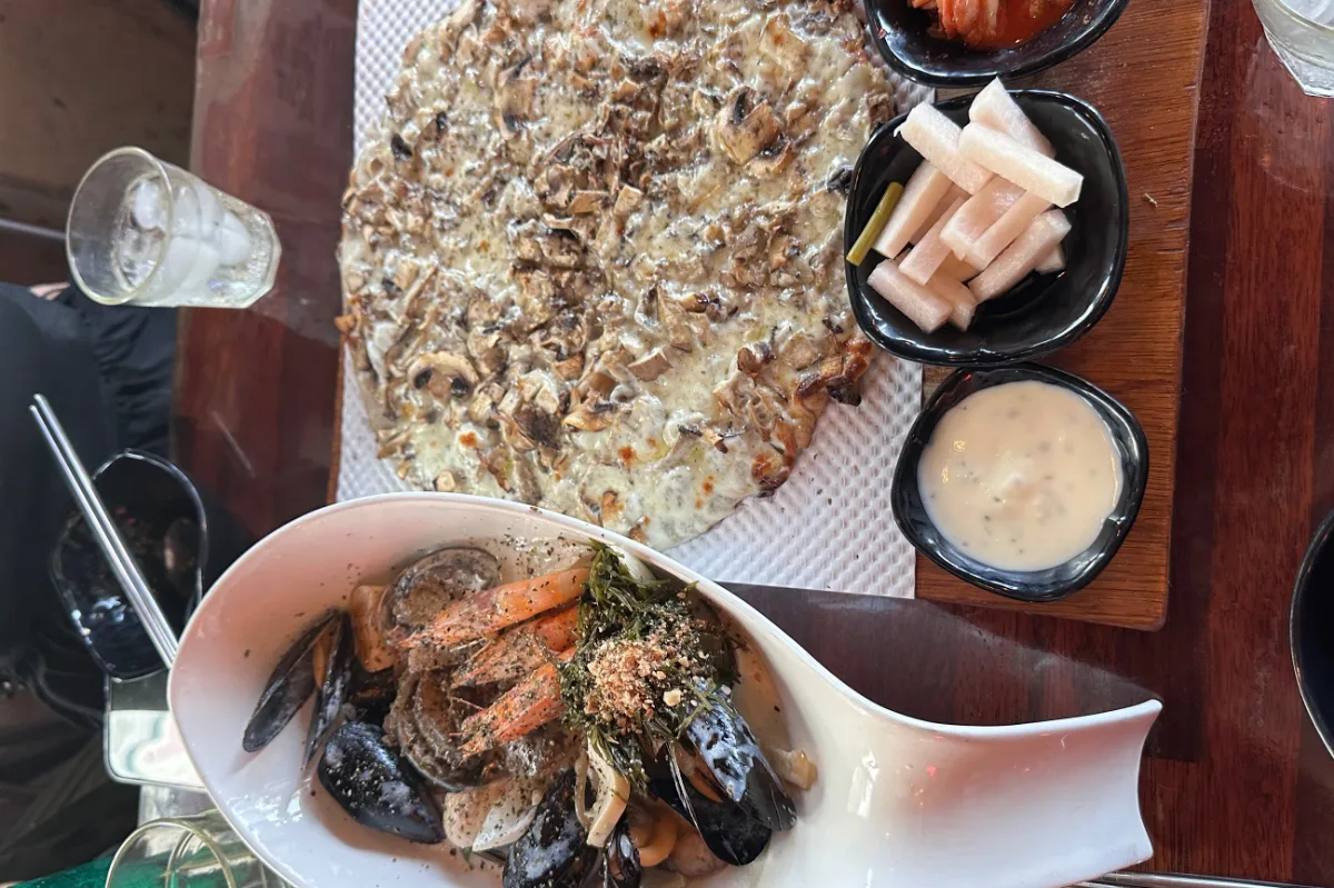 ソムソナイ 牛島本店 — 海鮮の一皿とキノコのピザ