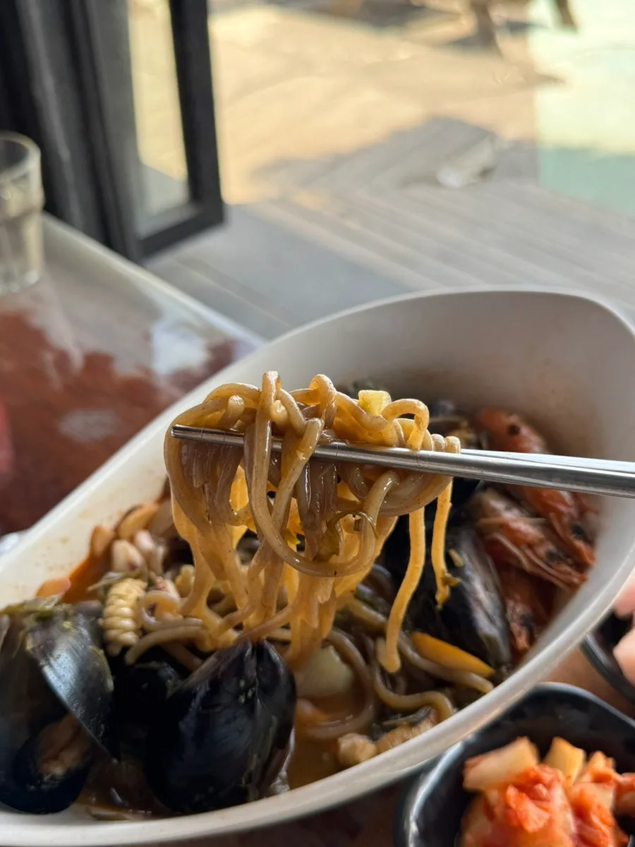 ソムソナイ 牛島本店 — ヒジキを練り込んだ麺を持ち上げたチャンポン