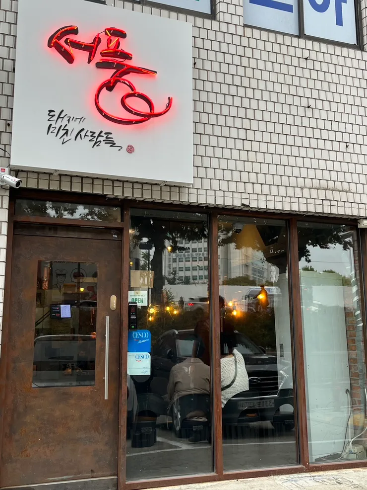 ソプン・テジエ・ミチン・サラムドゥル — 赤い看板とガラス張りの入口