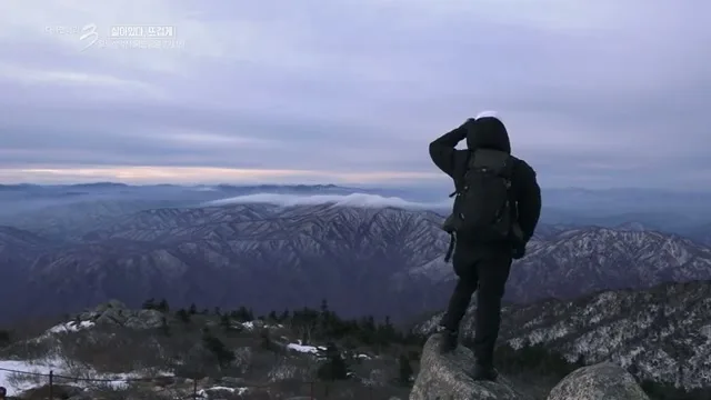 夜明けの稜線から山並みを見渡す登山者（KBS『ドキュメンタリー3日』より）