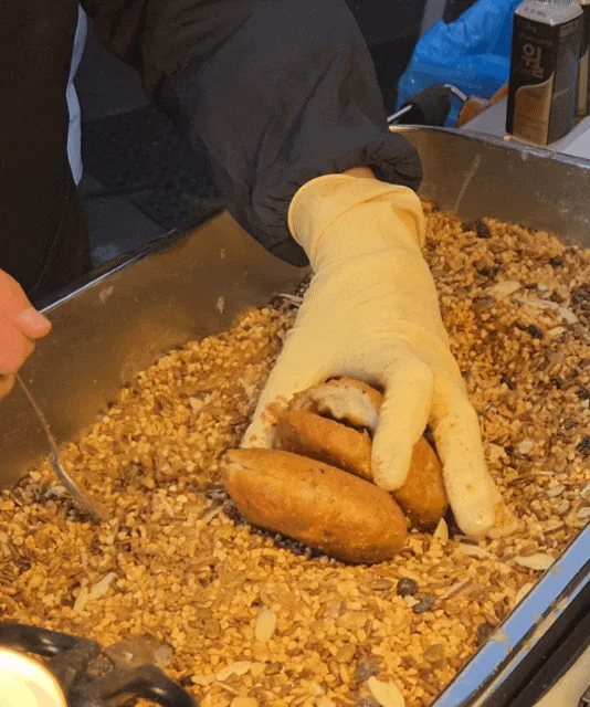 スンギ・シアホットク — 焼いたホットクを種のトレーに押し込んで詰める手元