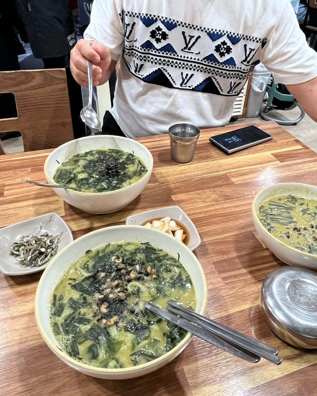 新済州ボマルカルグクス 本店 — 貝のスープが並ぶ食卓