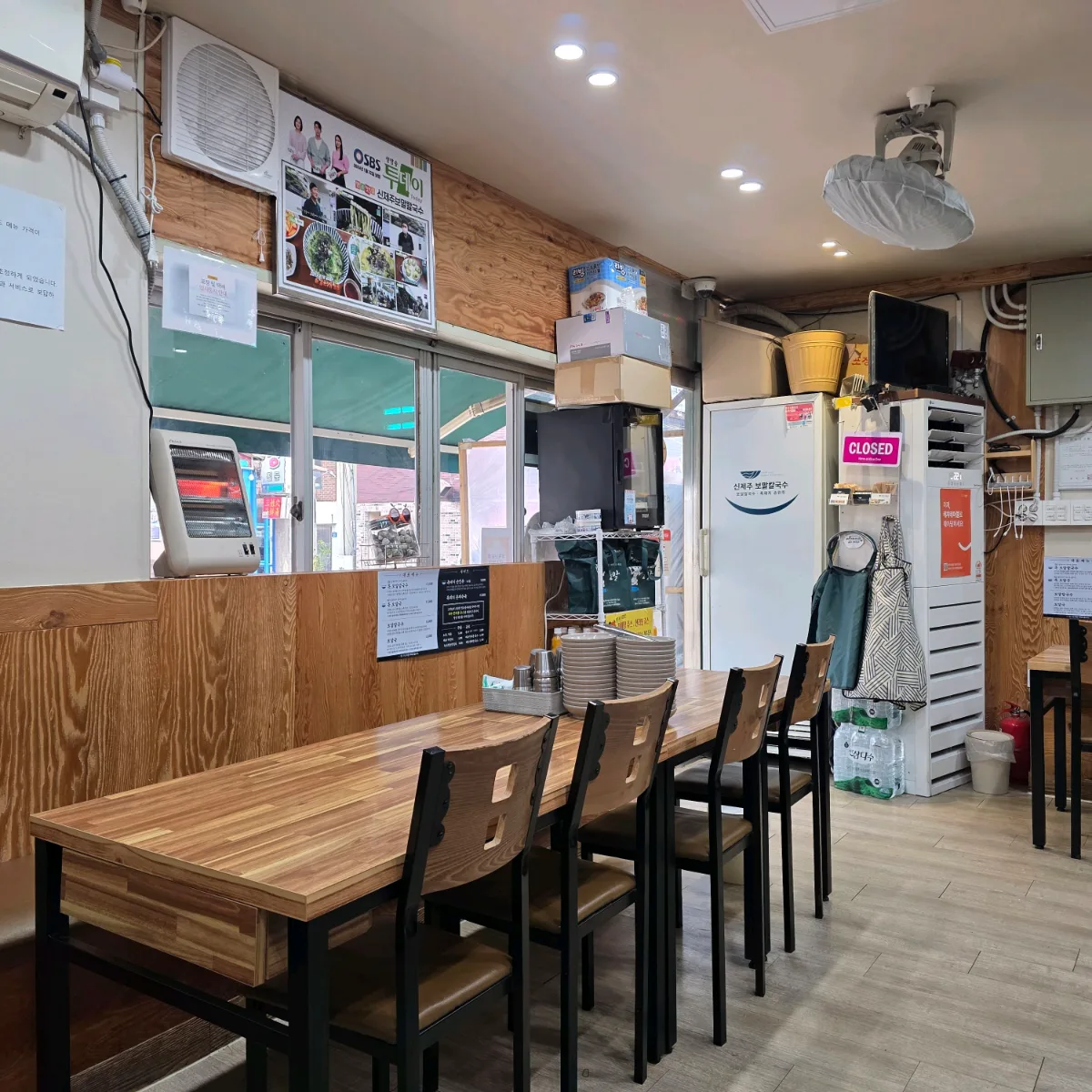 新済州ボマルカルグクス 本店 — 木目のテーブルが並ぶ店内