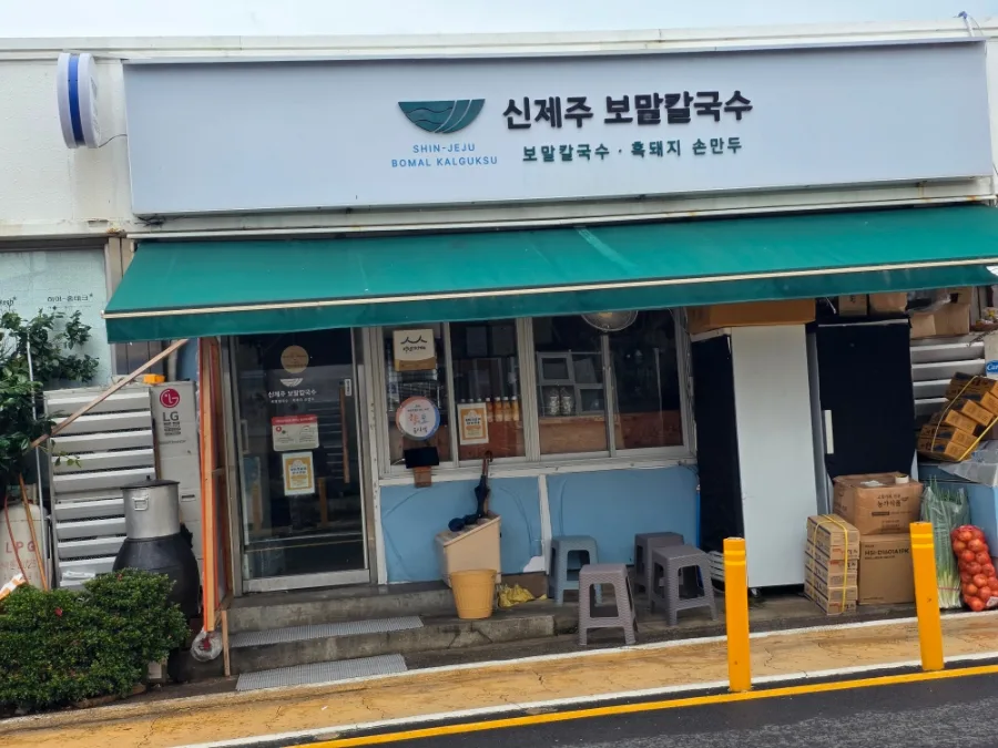 新済州ボマルカルグクス 本店 — 緑のひさしがある店先