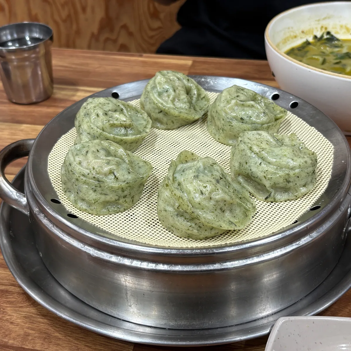 蒸し器に並ぶ緑色の餃子