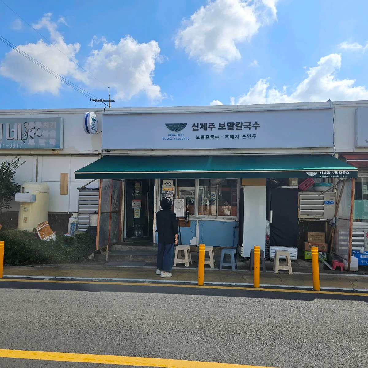 緑のひさしの店先と順番待ち用の椅子
