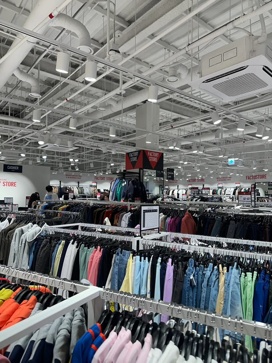 新世界サイモン プレミアムアウトレット 驪州店 — 衣類がずらりと並ぶ売り場