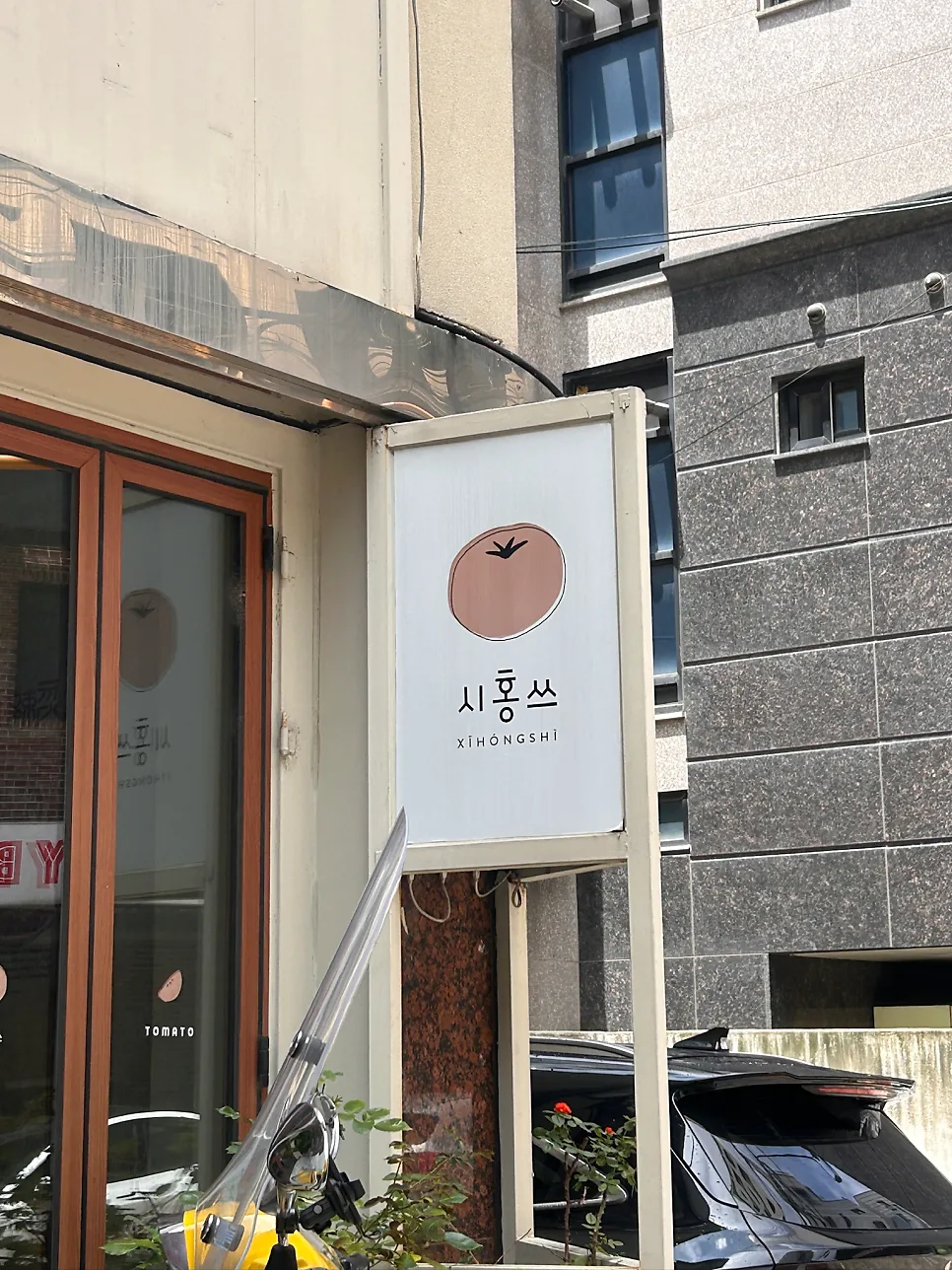 トマトの絵の白い看板と入口