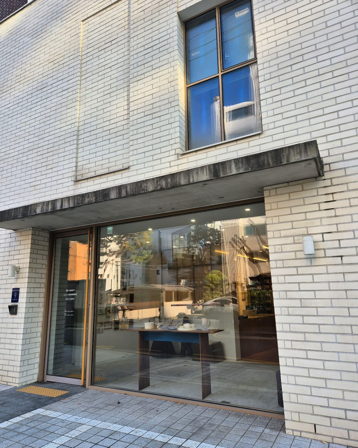 SIKIJANG — 白いレンガと大きなガラス窓の店