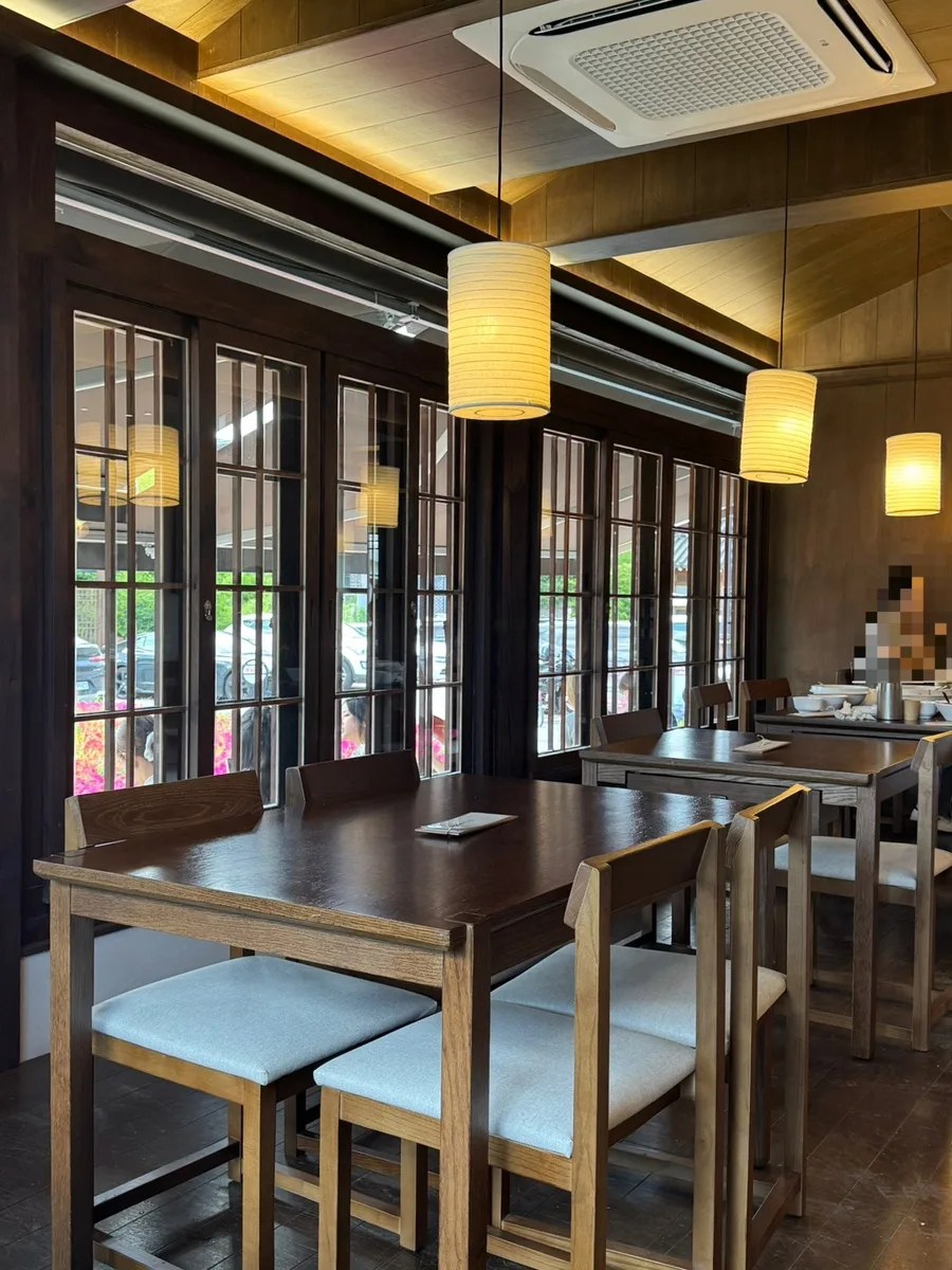 新羅製麺 慶州店 — 木のテーブルが並ぶ店内