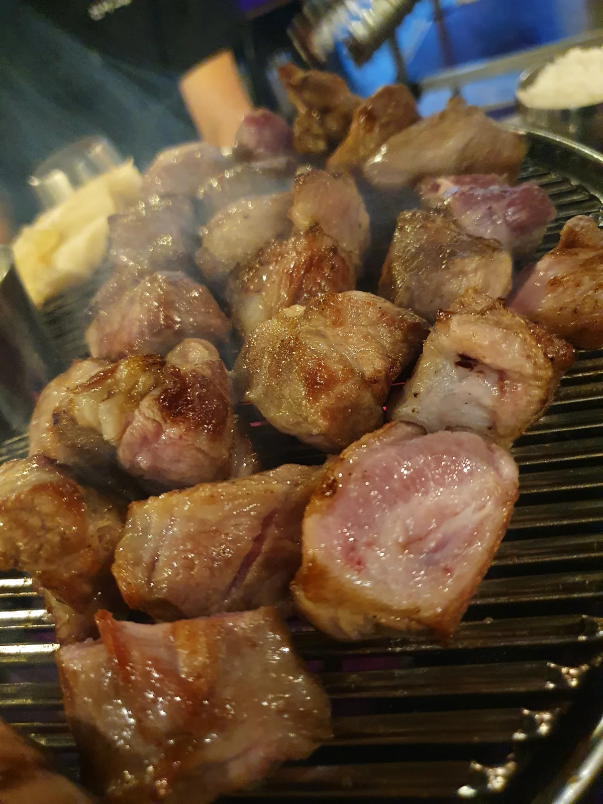 網の上で焼かれる角切りの豚肉
