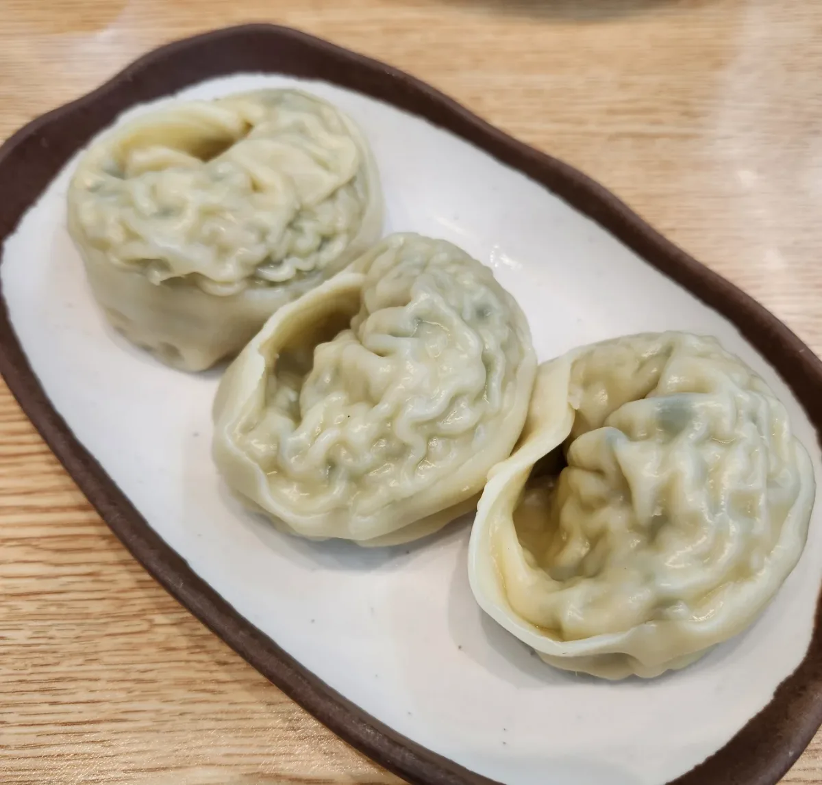 神仙ソルロンタン 明洞店 — 皿に盛られた蒸しマンドゥ3個