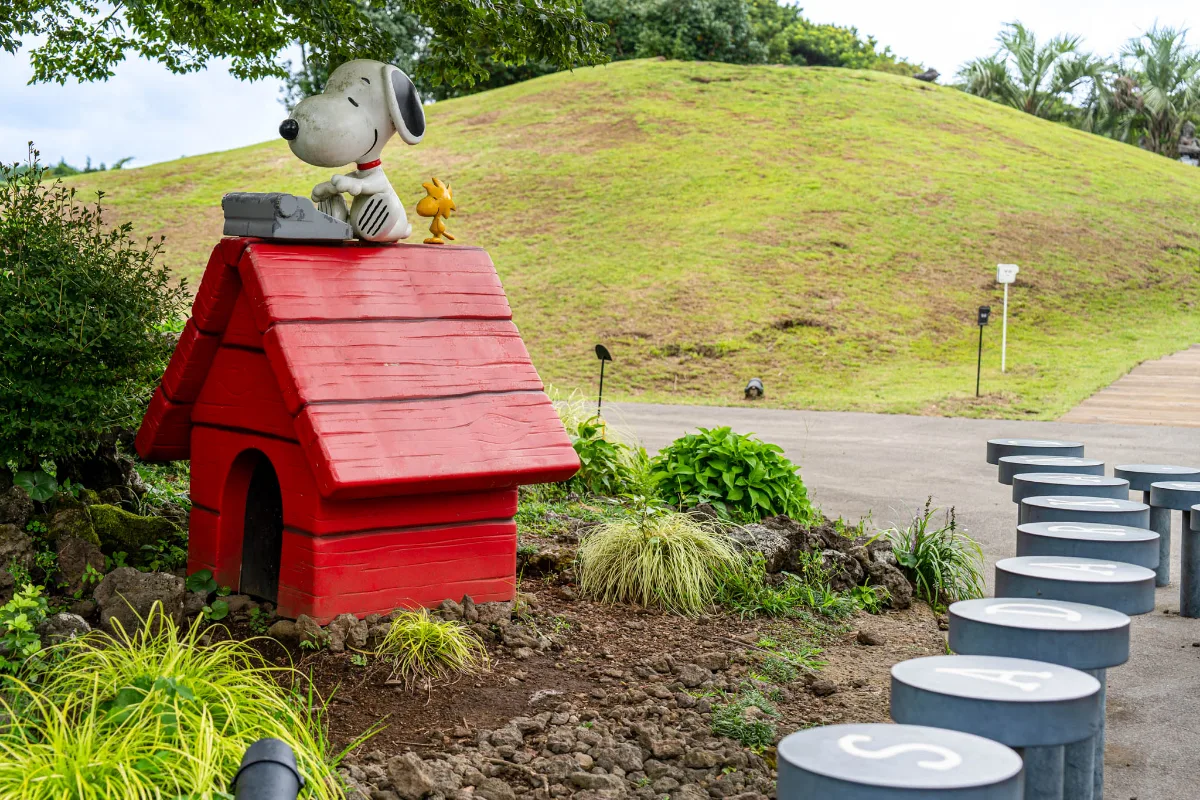 スヌーピーガーデン — 赤い犬小屋の屋根に座るスヌーピーとウッドストック
