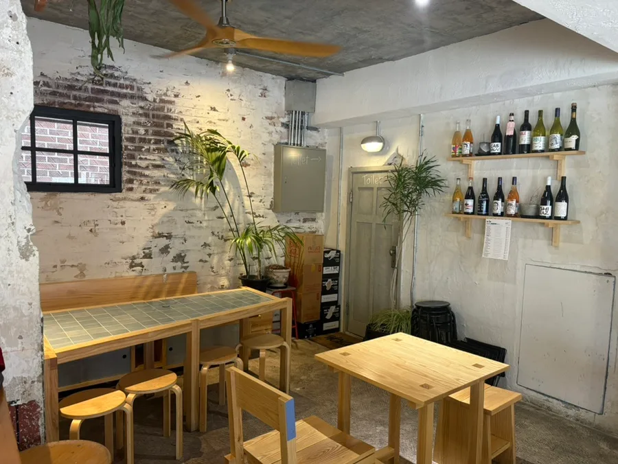 so far — 木のテーブルが並ぶ店内