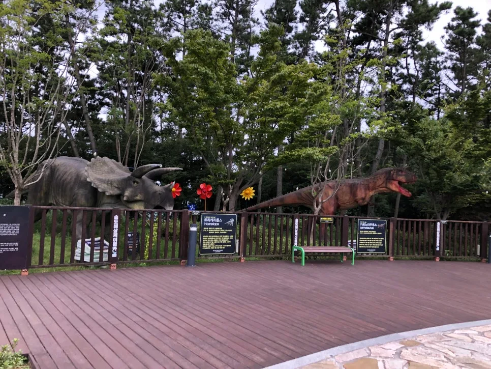 木々の間に立つ恐竜の模型